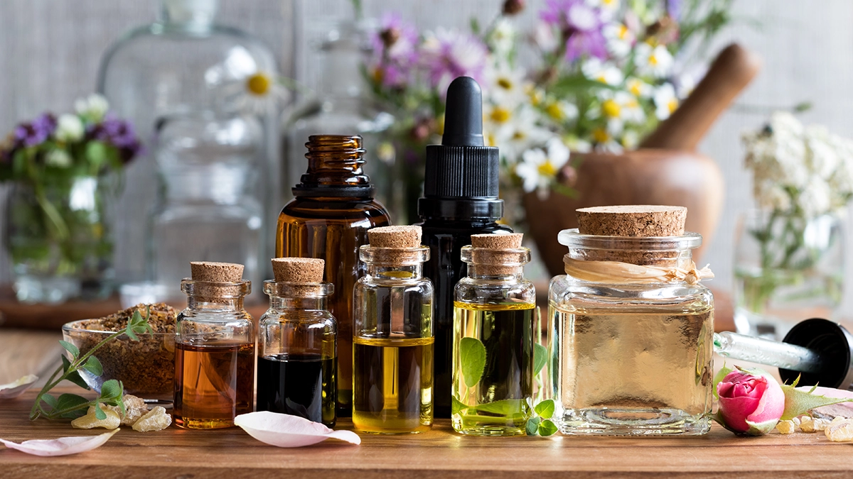 Various essential oils in glass bottles on a wooden surface, ideal for treating athlete's foot naturally
