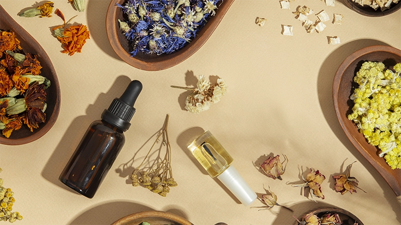 lots of essential oils lay on the table and with a bunch of aromatherapy ingredient