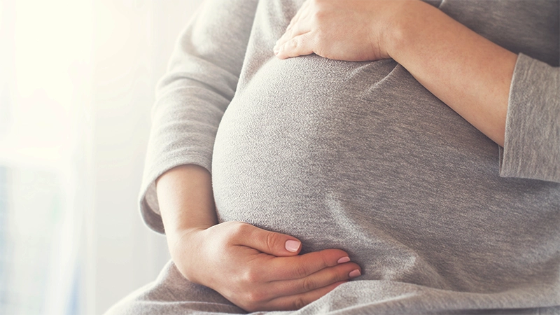 photo of a woman holding her pregnant belly