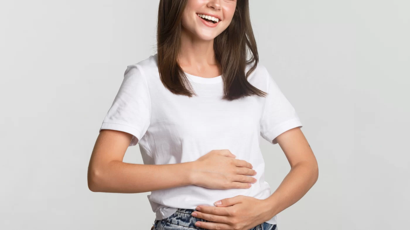 photo of a woman smiling while holding her belly