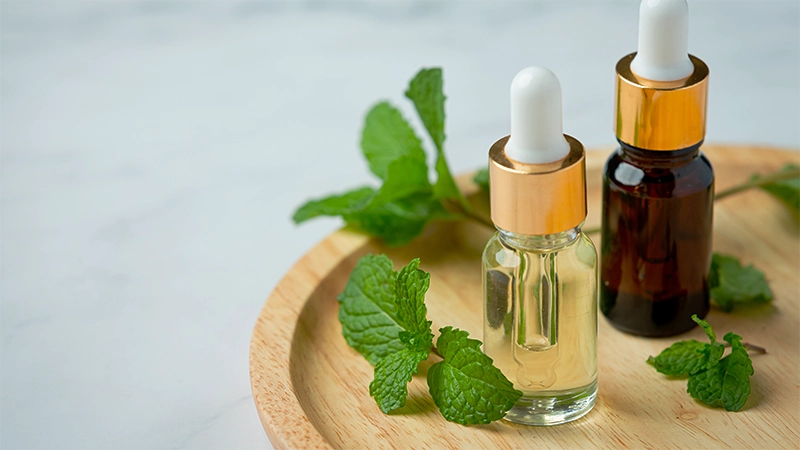 photo of peppermint essential oils on the top of a wooden plate