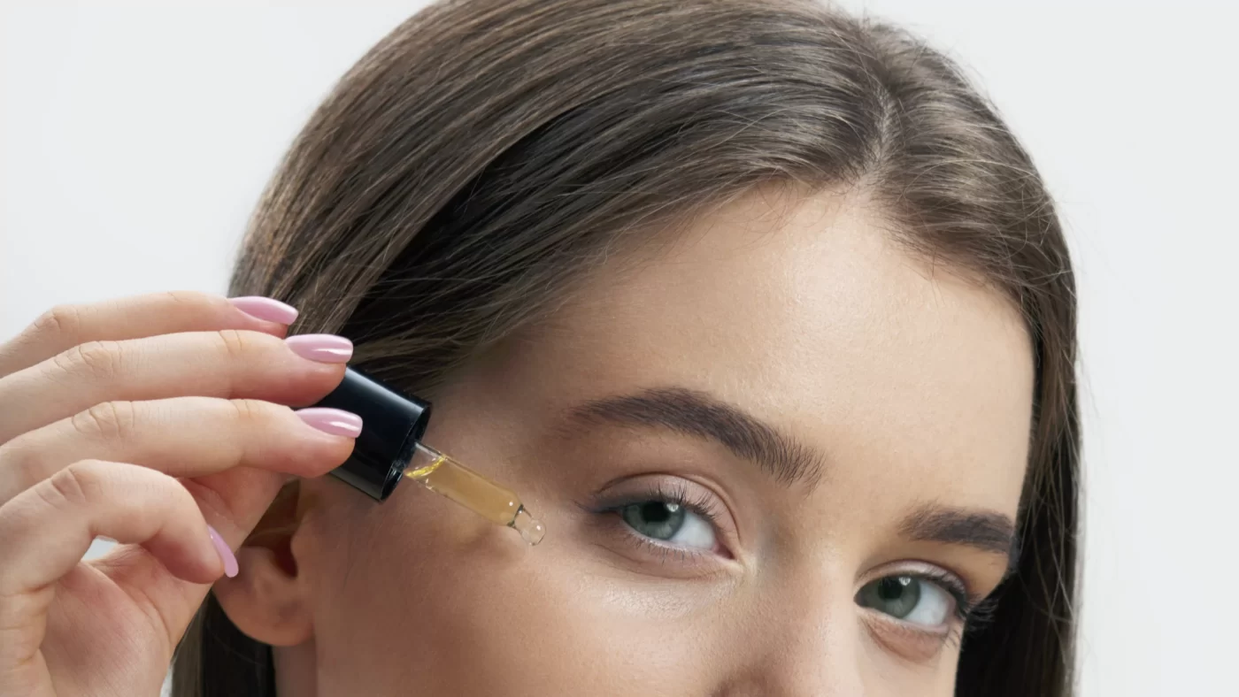 photo of a woman applying essential oils on her face