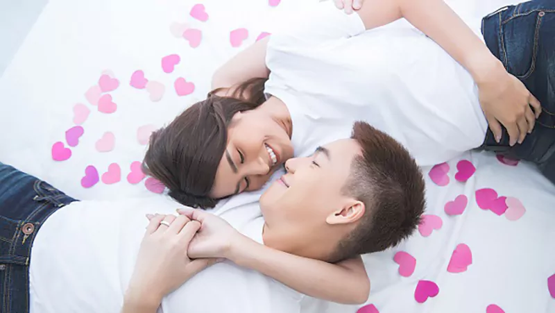 happy Asian couple in bed