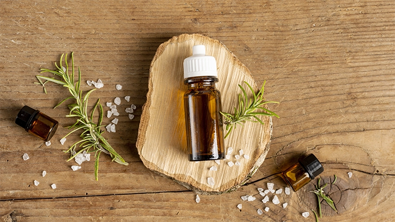 A photo of essential oils lay on the piece of wood