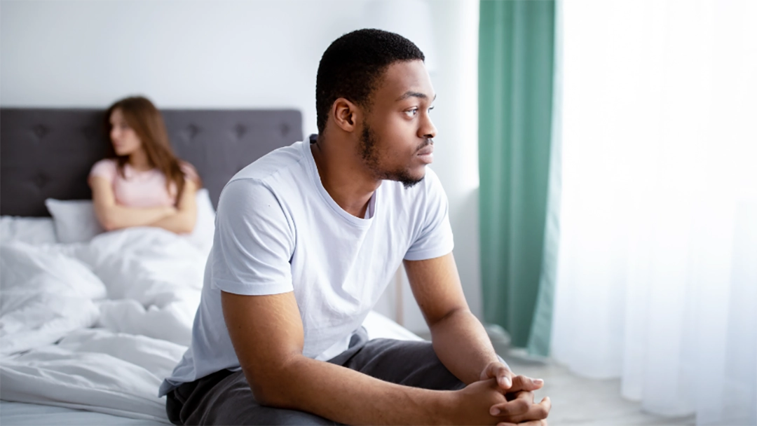 Man sitting on edge of bed with low testosterone