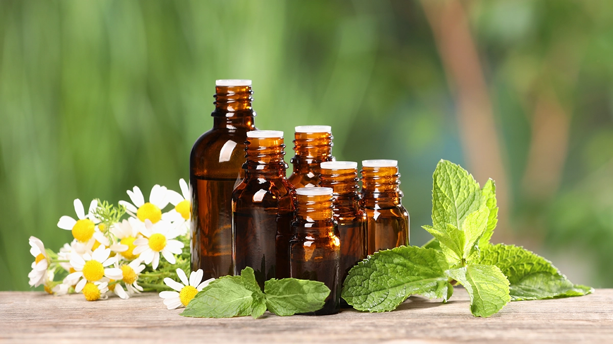 Bottles of various essential oils on a wooden table